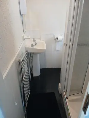 a white bathroom with a sink and a shower at The Osprey Hotel in Blackpool