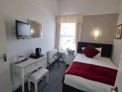 a hotel room with a bed and a desk and a television at Clifton Villa - Southport in Southport