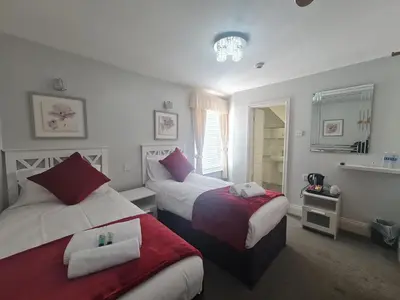 a hotel room with two beds and a bathroom at Clifton Villa - Southport in Southport