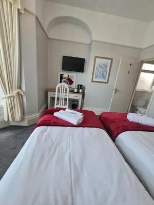 a bedroom with two beds with red and white sheets at Clifton Villa - Southport in Southport