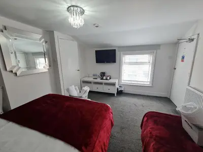 a bedroom with a red bed and a desk at Clifton Villa - Southport in Southport