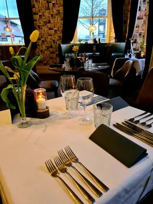 a table with a white table cloth with forks and glasses at The Royal Station Hotel in Carnforth