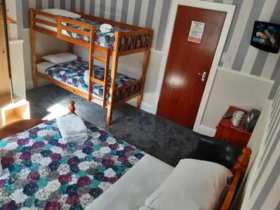 a small bedroom with a bed and a bunk bed at Wellington Hotel in Blackpool