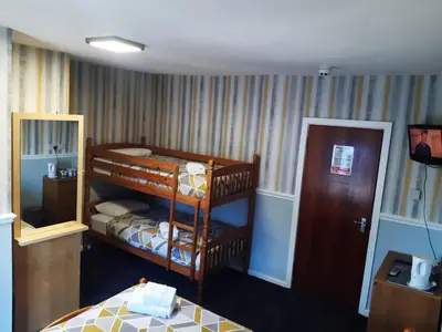 a bedroom with a bunk bed and a mirror at Wellington Hotel in Blackpool