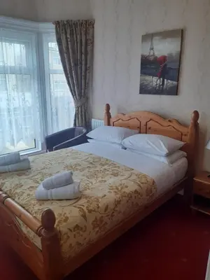 a bedroom with a large bed with a wooden frame at Wellington Hotel in Blackpool