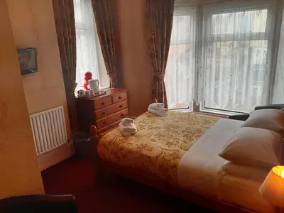 a bedroom with a bed with a dresser and a window at Wellington Hotel in Blackpool