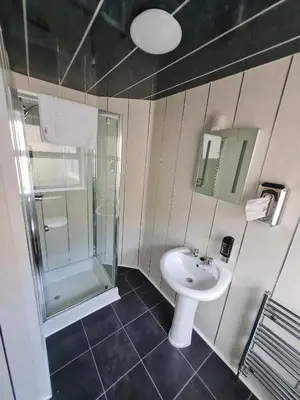 a bathroom with a sink and a shower at Queens Plaza Hotel in Blackpool