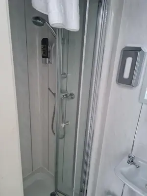 a shower with a glass door in a bathroom at Queens Plaza Hotel in Blackpool