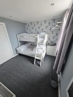 a room with two bunk beds and a chair at Queens Plaza Hotel in Blackpool