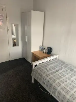 a bedroom with a bed and a dresser and a mirror at Alderley Hotel Blackpool in Blackpool