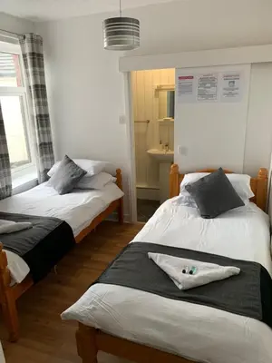a bedroom with two beds and a window at Alderley Hotel Blackpool in Blackpool