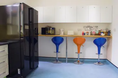 a kitchen with four blue and orange bar stools at Renshaw Guest House in Liverpool