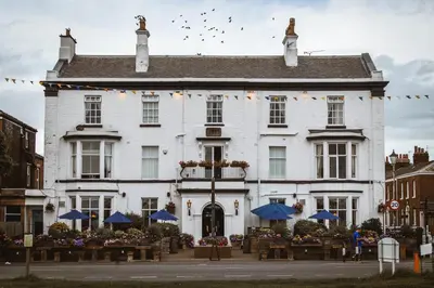 a white building with tables in front of it at The Queens Hotel in Lytham St Annes