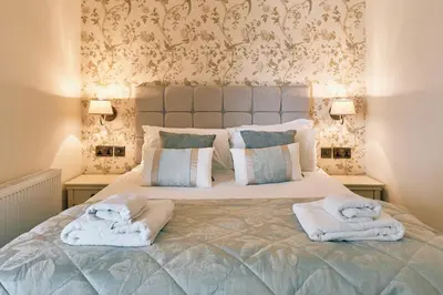a bedroom with a bed with towels on it at The Queens Hotel in Lytham St Annes