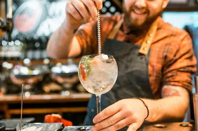 a man is preparing a drink in a wine glass at The Queens Hotel in Lytham St Annes