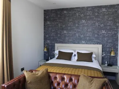 a bedroom with a bed with a leather couch at 1823 Spinning Block in Clitheroe