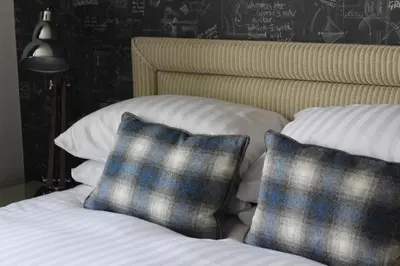 a bed with two blue and white pillows on it at 1823 Spinning Block in Clitheroe