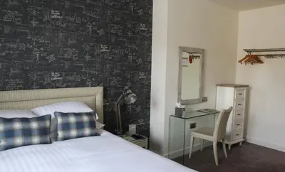 a bedroom with a bed and a desk and a mirror at 1823 Spinning Block in Clitheroe