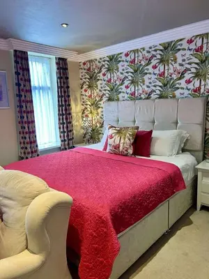 a bedroom with a large bed with a red blanket at Number One South Beach in Blackpool