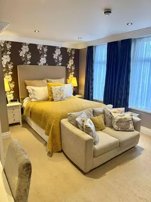 a large bedroom with a bed and a couch at Number One South Beach in Blackpool