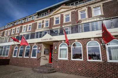 a brick building with red flags in front of it at Number One South Beach in Blackpool