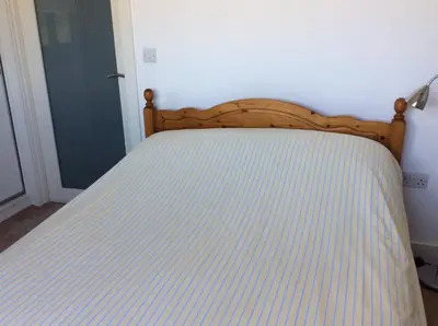 a bed with a wooden headboard in a bedroom at HH Accommodation in Millom