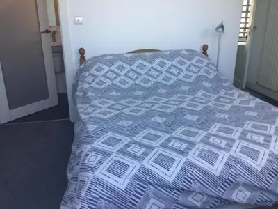 a bed with a blue and white comforter in a room at HH Accommodation in Millom