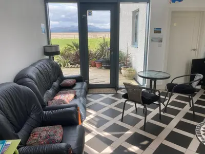 a living room with a couch and a table and chairs at HH Accommodation in Millom