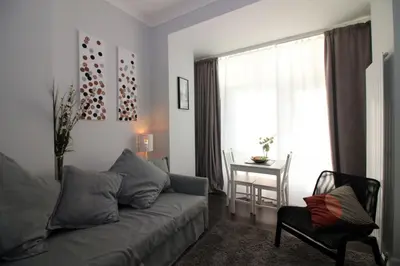 a living room with a couch and a table and a window at Sweet Suites Lytham in Lytham St Annes