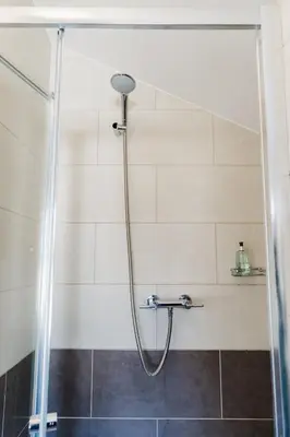 a shower with a shower head in a bathroom at Sweet Suites Lytham in Lytham St Annes