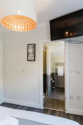 a room with a bed and a chandelier at Sweet Suites Lytham in Lytham St Annes