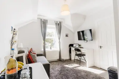 a living room with a couch and a desk at Sweet Suites Lytham in Lytham St Annes