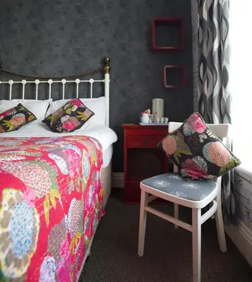 a bedroom with a bed and a chair and a table at The Gallery in Blackpool