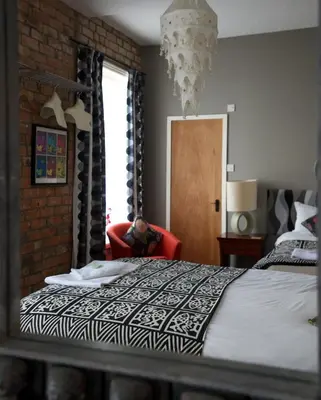 a bedroom with a bed with a black and white comforter at The Gallery in Blackpool