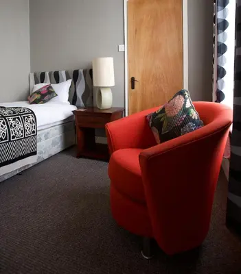 a bedroom with a red chair and a bed at The Gallery in Blackpool