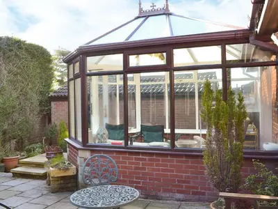 a conservatory with a glass roof in a garden at Carmichael in Longridge