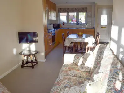 a living room with a couch and a kitchen with a table at Carmichael in Longridge