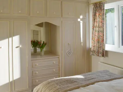 a bedroom with a bed with a dresser and a mirror at Carmichael in Longridge