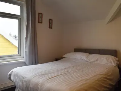 a bedroom with a white bed with a window at Ocean View House in Blackpool