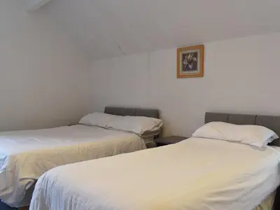 a room with two beds and a picture on the wall at Ocean View House in Blackpool
