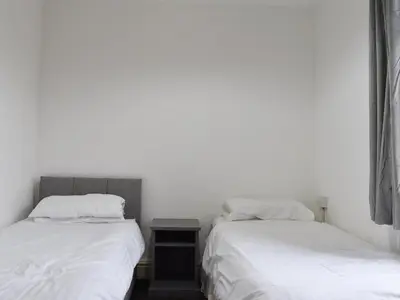 two beds in a room with white walls at Ocean View House in Blackpool