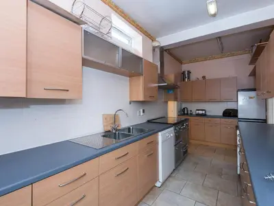 a large kitchen with wooden cabinets and a sink at Ocean View House in Blackpool