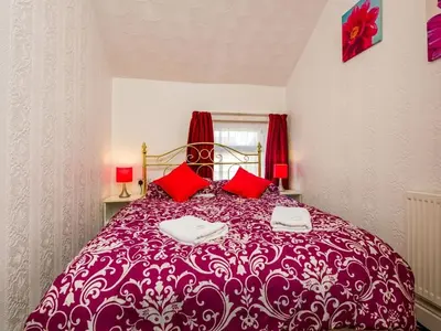 a bedroom with a purple bed with red pillows at Holmeleigh Hotel in Blackpool