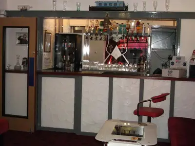 a bar with a red chair in front of it at Holmeleigh Hotel in Blackpool
