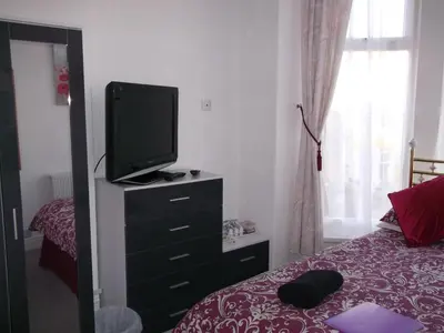 a bedroom with a tv on a dresser with a bed at Holmeleigh Hotel in Blackpool
