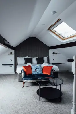a bedroom with a bed and a blue couch with red pillows at Arthur's Bar & Accommodation in Southport