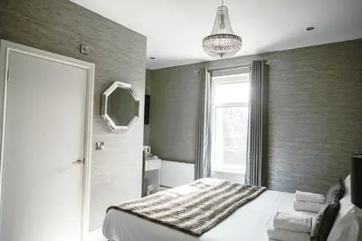 a bedroom with a bed and a mirror and a window at Arthur's Bar & Accommodation in Southport