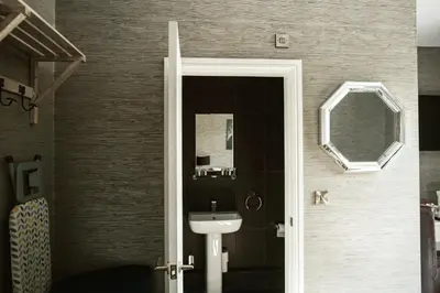 a bathroom with a sink and a mirror at Arthur's Bar & Accommodation in Southport