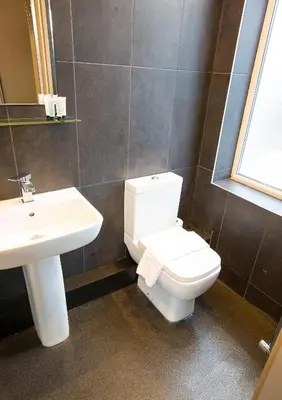 a bathroom with a white toilet and a sink at Arthur's Bar & Accommodation in Southport