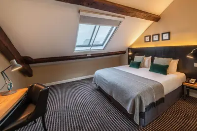 a bedroom with a bed and a desk and a window at The Resident Liverpool in Liverpool